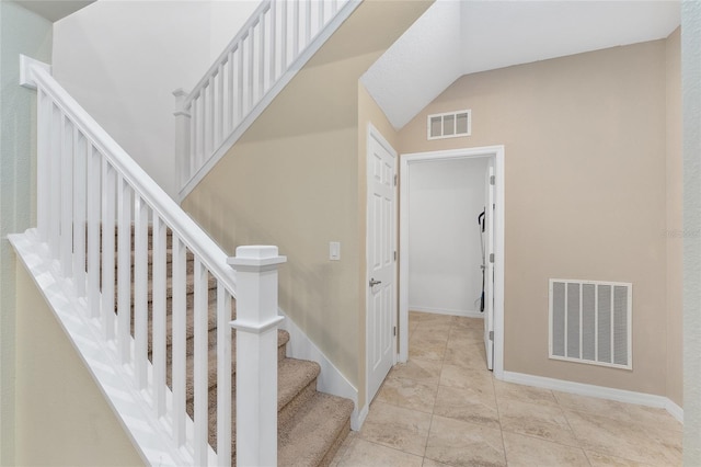 staircase featuring tile patterned floors and lofted ceiling