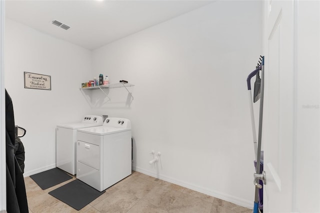 laundry area featuring light tile patterned floors and washer and clothes dryer