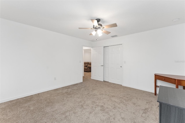 unfurnished bedroom featuring ceiling fan, a closet, and light carpet