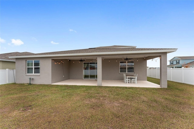 rear view of house with a patio area, ceiling fan, and a yard