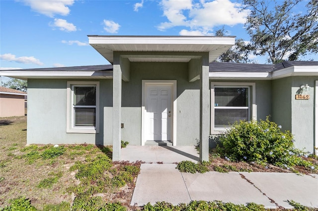 view of exterior entry featuring stucco siding