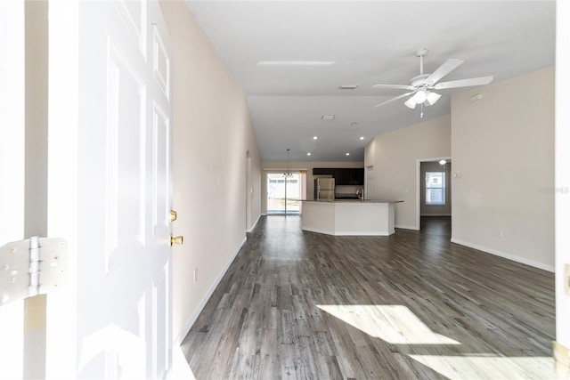 unfurnished living room with visible vents, lofted ceiling, a ceiling fan, baseboards, and dark wood-style flooring