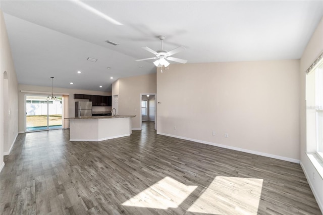 unfurnished living room featuring dark wood-type flooring, visible vents, lofted ceiling, and a sink