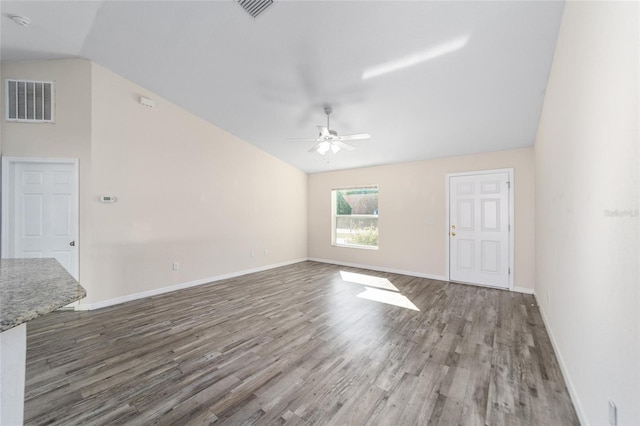 empty room with ceiling fan, visible vents, wood finished floors, and vaulted ceiling