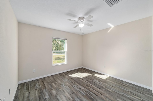 empty room featuring ceiling fan, wood finished floors, visible vents, and baseboards