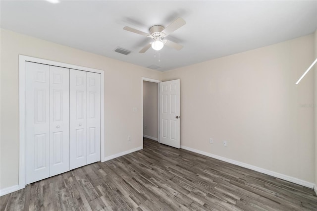 unfurnished bedroom with wood finished floors, visible vents, baseboards, ceiling fan, and a closet