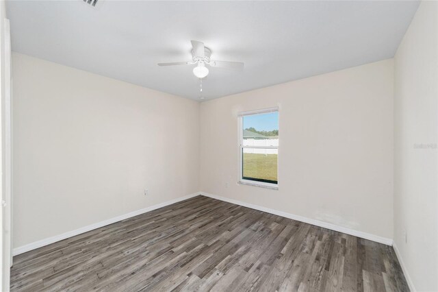 spare room featuring a ceiling fan, wood finished floors, and baseboards