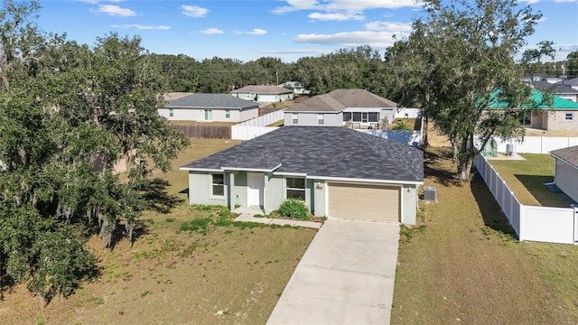 view of front of property featuring a front yard, fence, an attached garage, stucco siding, and concrete driveway