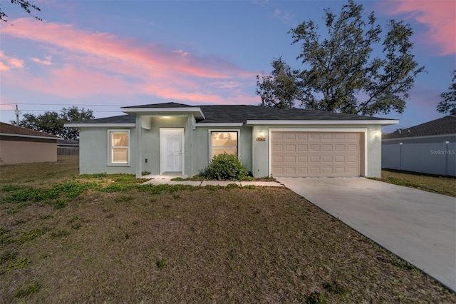 single story home with a front lawn, fence, stucco siding, a garage, and driveway