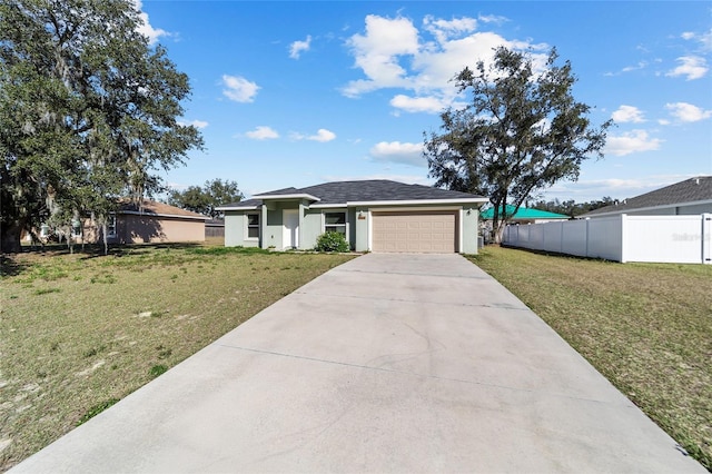 view of front of house featuring a garage, stucco siding, fence, a front lawn, and driveway