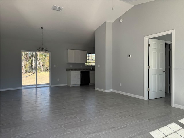 unfurnished living room featuring a chandelier, vaulted ceiling, and sink