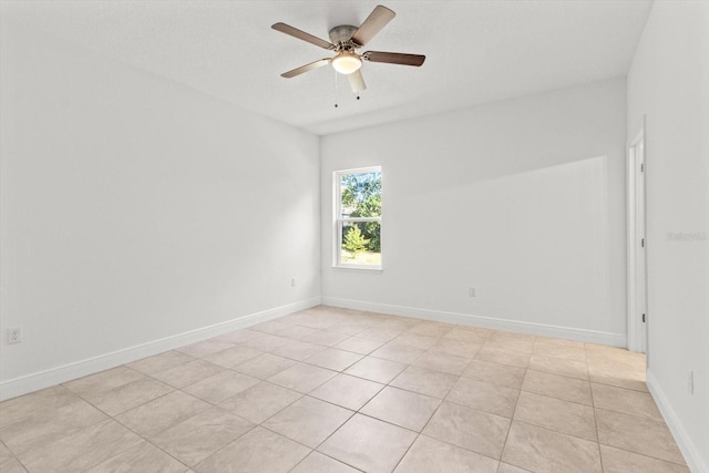 tiled spare room featuring ceiling fan