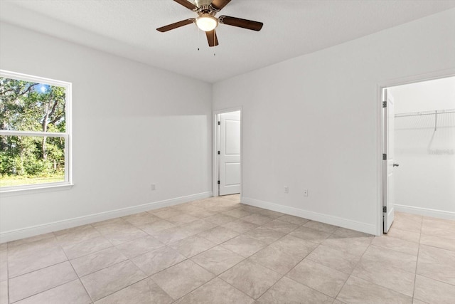 tiled empty room featuring ceiling fan