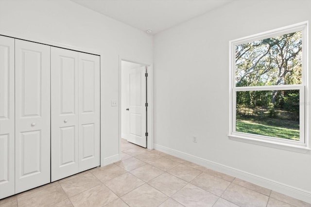 unfurnished bedroom with a closet and light tile patterned floors