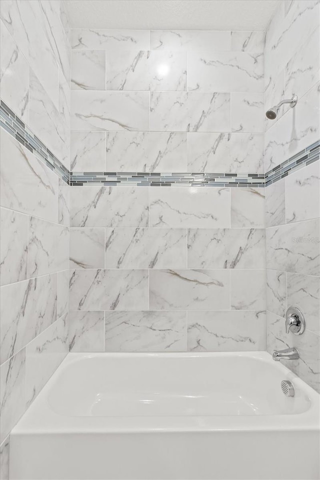 bathroom featuring tiled shower / bath