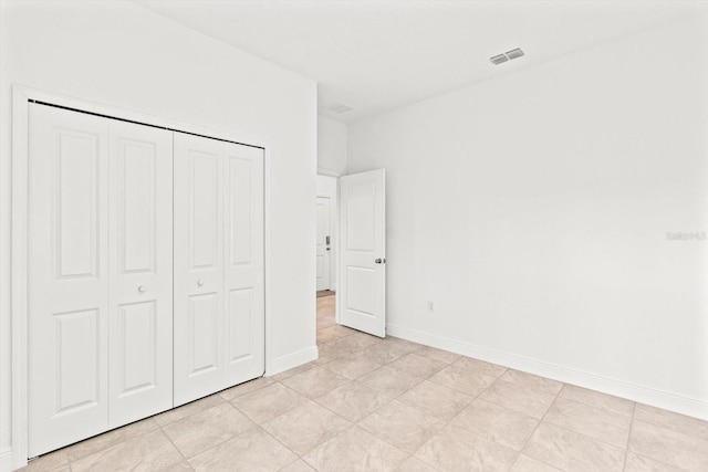 unfurnished bedroom with a closet and light tile patterned floors