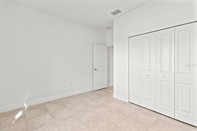 unfurnished bedroom featuring a closet and light tile patterned floors