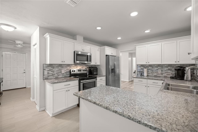 kitchen featuring tasteful backsplash, ceiling fan, sink, stainless steel appliances, and white cabinets