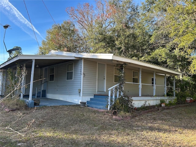 manufactured / mobile home featuring covered porch and a carport