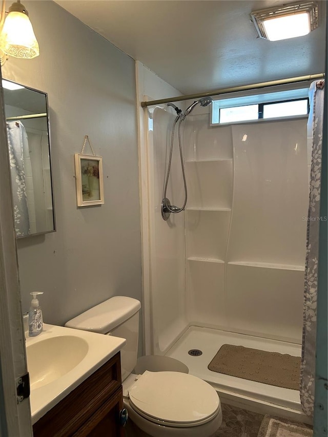 bathroom featuring toilet, vanity, and a shower with curtain