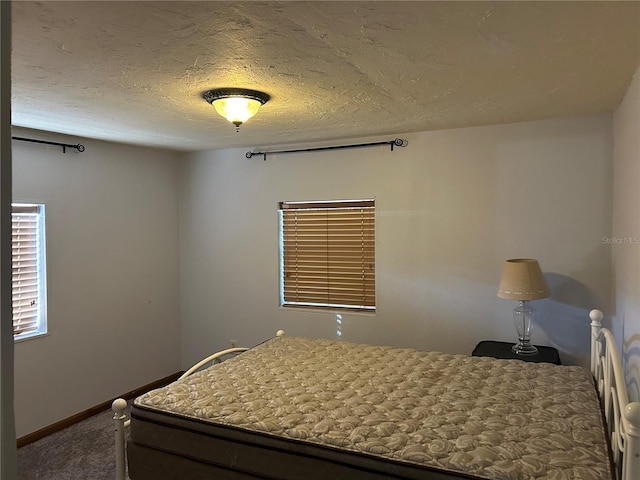 bedroom with a textured ceiling and carpet flooring