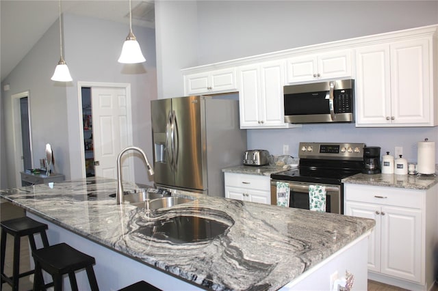 kitchen with white cabinets, stainless steel appliances, and decorative light fixtures