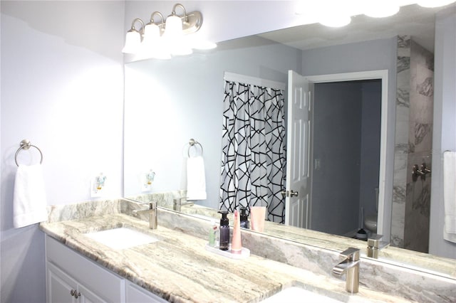 bathroom with vanity, curtained shower, and toilet