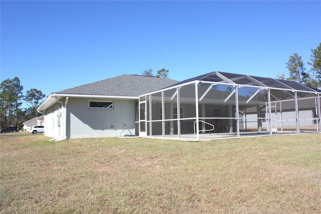 rear view of house featuring a lawn and glass enclosure