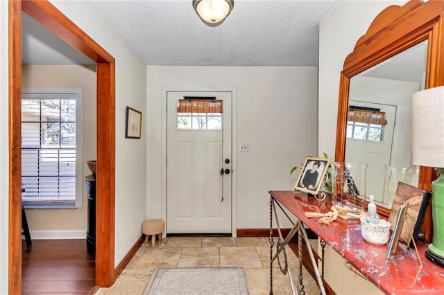 foyer entrance with a textured ceiling