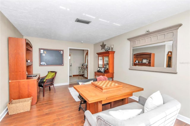 dining space featuring hardwood / wood-style floors and a textured ceiling