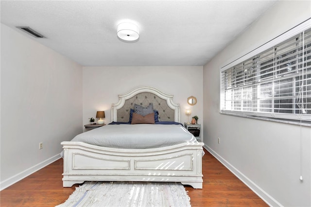 bedroom with a textured ceiling and hardwood / wood-style flooring