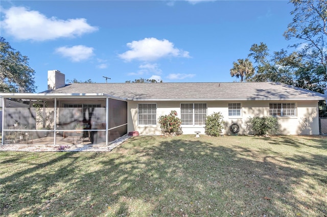 rear view of property with a patio area, a sunroom, and a yard