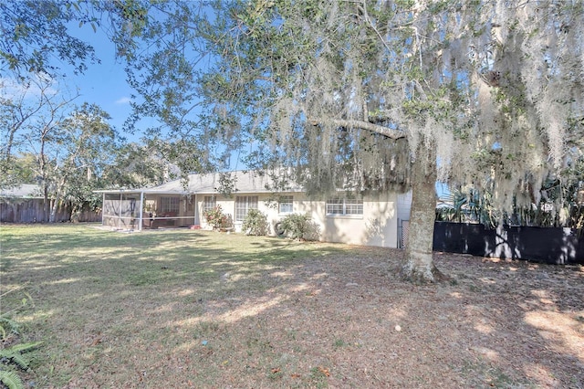 rear view of property with a sunroom and a lawn