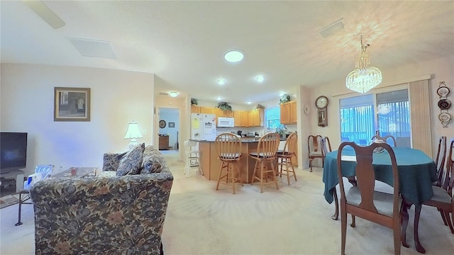 carpeted dining room with a chandelier