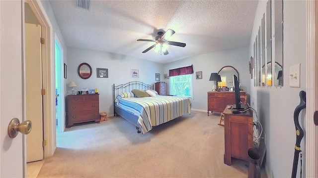 carpeted bedroom with ceiling fan and a textured ceiling