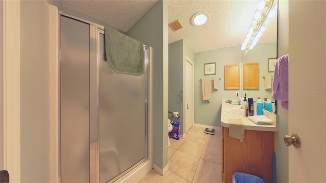 bathroom with vanity, an enclosed shower, tile patterned flooring, and a textured ceiling