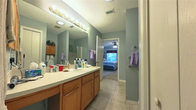 bathroom with tile patterned flooring, a shower with door, a textured ceiling, and vanity