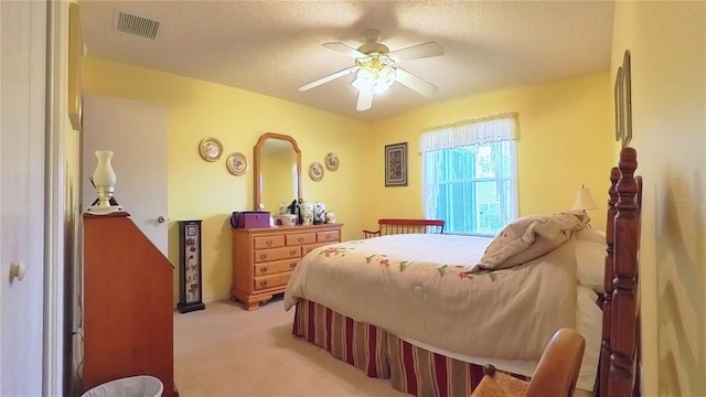 carpeted bedroom featuring a textured ceiling and ceiling fan