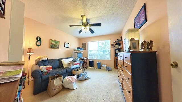 living area with ceiling fan, a textured ceiling, and carpet flooring