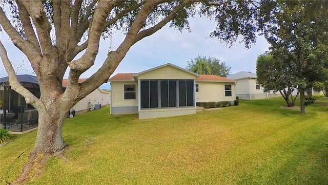 back of property featuring a lawn, central AC, and a sunroom