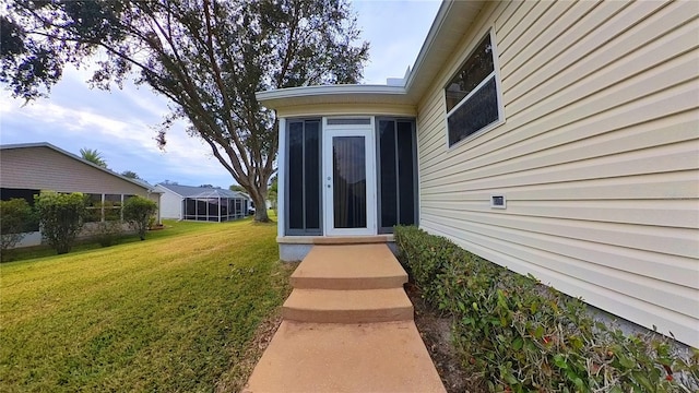 view of exterior entry with a lawn