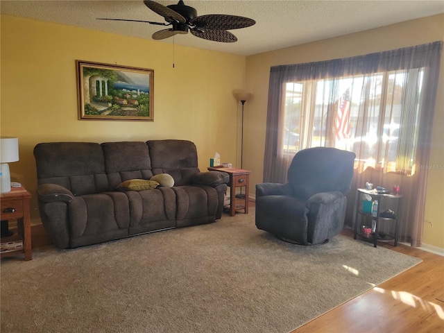 living room with hardwood / wood-style floors, ceiling fan, and a textured ceiling