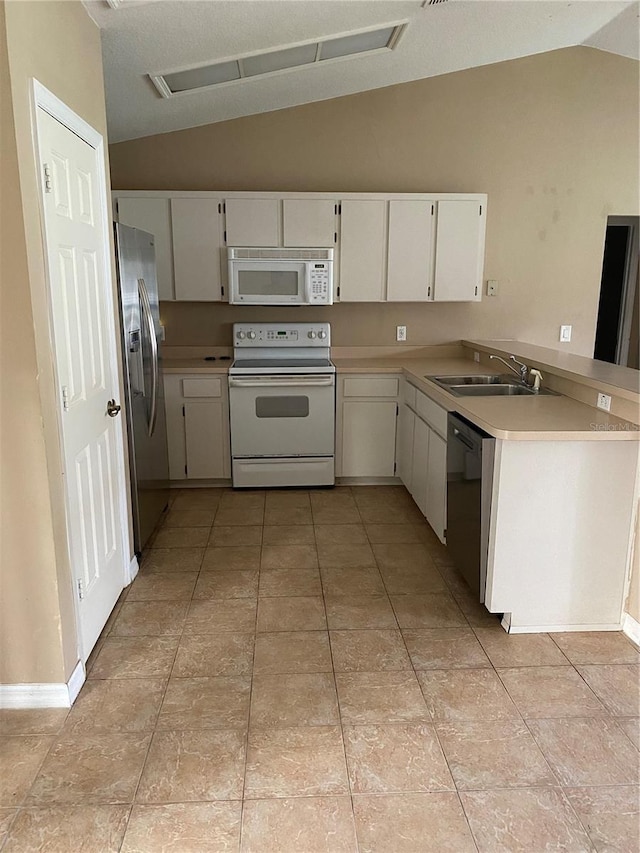 kitchen featuring white appliances, white cabinetry, vaulted ceiling, and sink