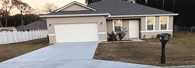 ranch-style home with a garage and a yard