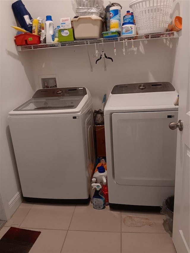 laundry room with washing machine and dryer and light tile patterned flooring