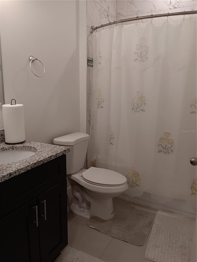 bathroom with toilet, vanity, and tile patterned floors