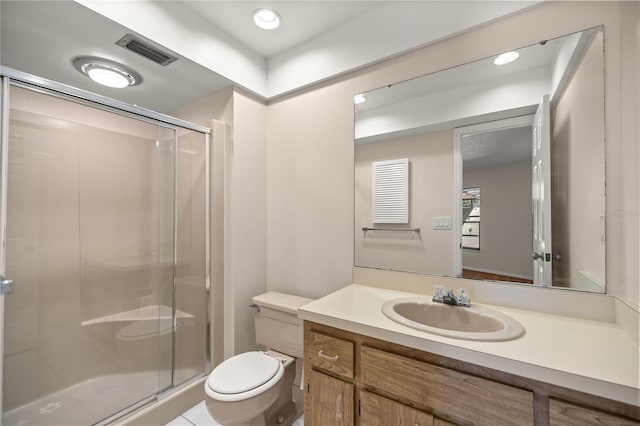 bathroom featuring an enclosed shower, vanity, and toilet