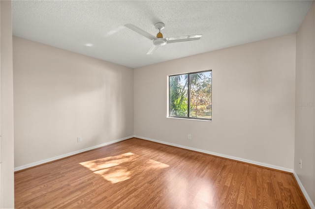 spare room featuring a textured ceiling, ceiling fan, and wood-type flooring