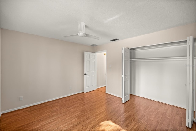 unfurnished bedroom with ceiling fan, light hardwood / wood-style floors, a closet, and a textured ceiling