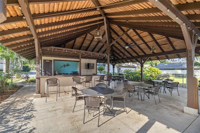 view of patio / terrace featuring ceiling fan, exterior bar, and a gazebo